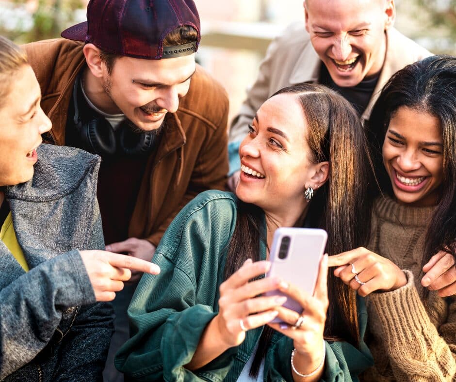 A group of Gen Z adults interacting with each other and their smart phones