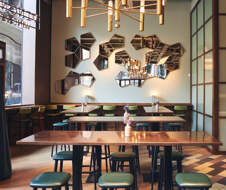 The latest restaurant trends are depicted by a small, modern dining room, with hexagonal mirrors and large window to the street.