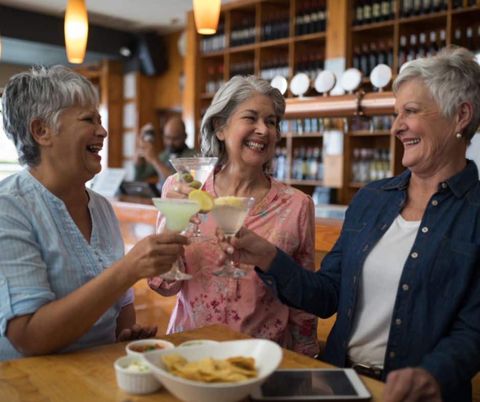 senior housing trends depicted by three older women sharing a toast in a senior housing bar