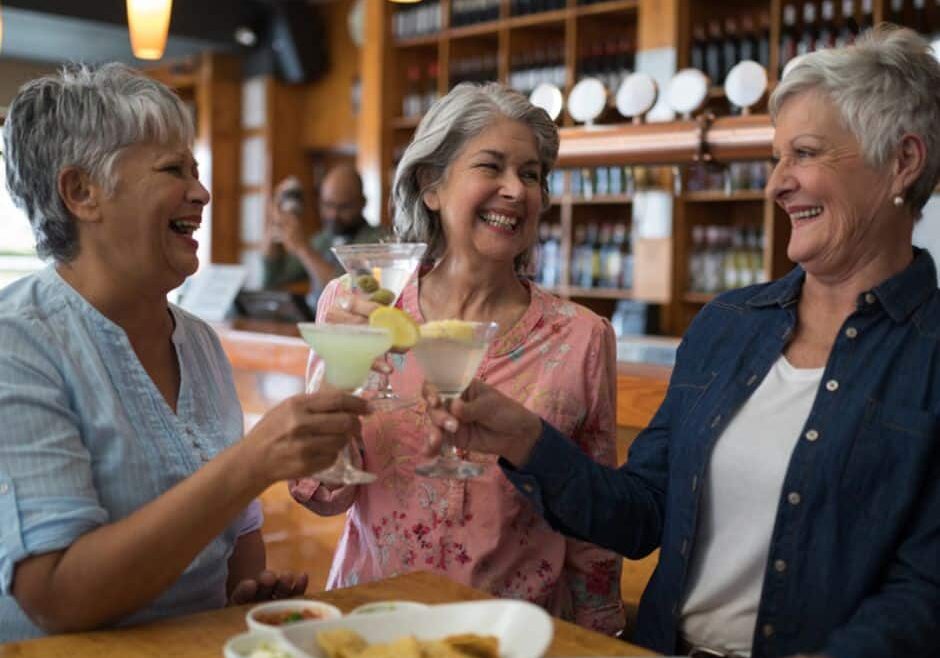 senior housing trends depicted by three older women sharing a toast in a senior housing bar